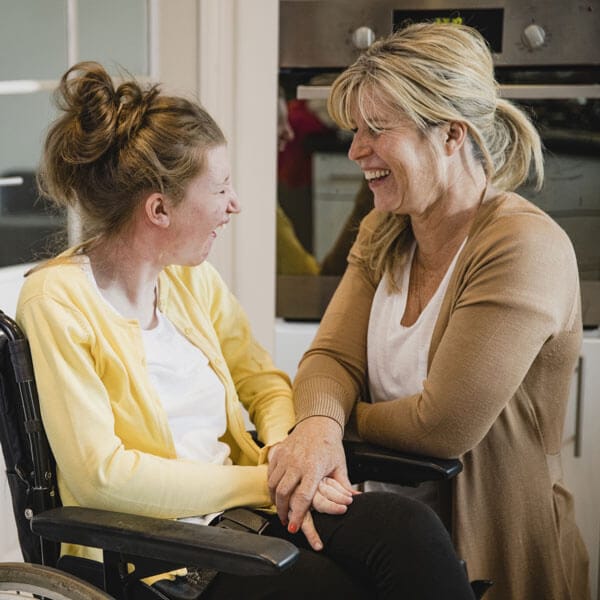 Worker talking to a group home member in wheelchair